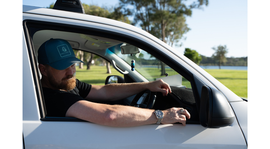 man in his car with his trucker cap