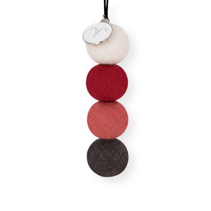 Aries Zodiac Smelly Balls four reusable wool felt scent balls in a fiery colour palette of deep crimson red, warm coral, crisp cream, and charcoal black, strung on an elastic cord.