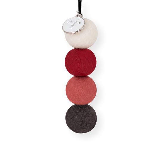 Aries Zodiac Smelly Balls four reusable wool felt scent balls in a fiery colour palette of deep crimson red, warm coral, crisp cream, and charcoal black, strung on an elastic cord.