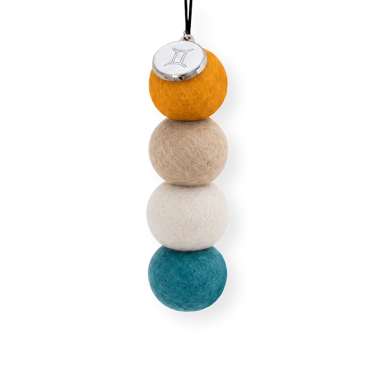 Four reusable wool felt air freshener balls in warm mustard yellow, sandy beige, soft cream, and vibrant teal blue for the Gemini Zodiac Set.