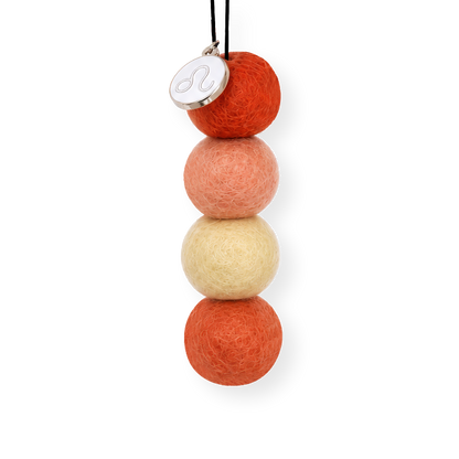 Four reusable wool felt air freshener balls in vibrant crimson red, warm peach, soft pale yellow, and burnt orange for the Leo Zodiac Set.