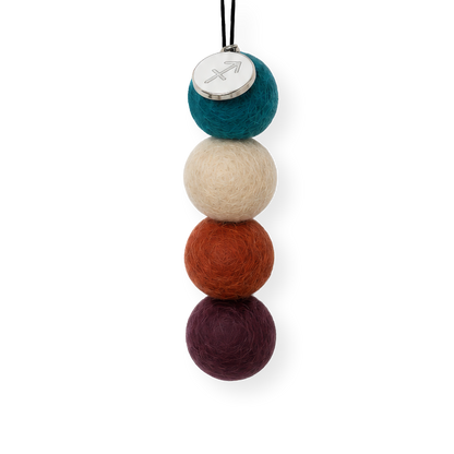 Four reusable wool felt air freshener balls in deep ocean teal blue, soft sandy beige, rust orange, and rich plum purple for the Sagittarius Zodiac Set.