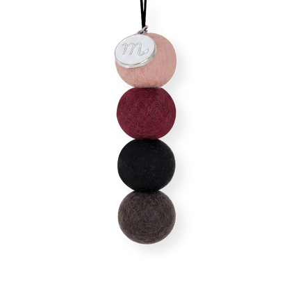 Four reusable wool felt air freshener balls in dusky blush pink, rich maroon burgundy, charcoal black, and dark slate grey for the Scorpio Zodiac Set.