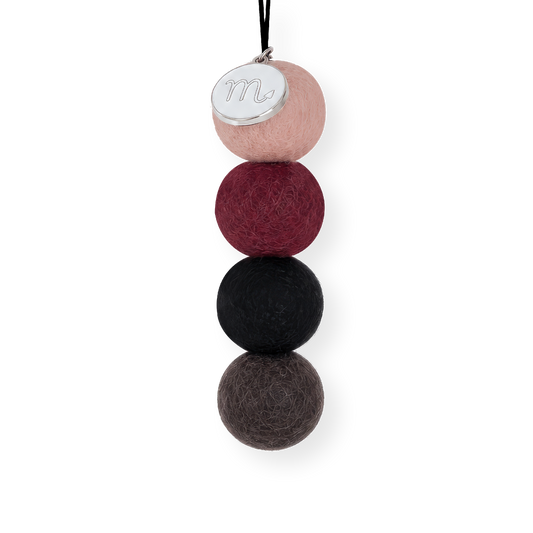 Four reusable wool felt air freshener balls in dusky blush pink, rich maroon burgundy, charcoal black, and dark slate grey for the Scorpio Zodiac Set.